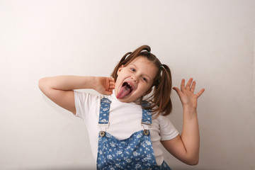 funny girl child builds faces, shows tongue