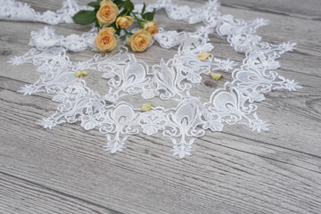 Fototapeta na wymiar wooden background with spring flowers roses and lace ribbon. Happy womans day. The texture of lace on wooden background.