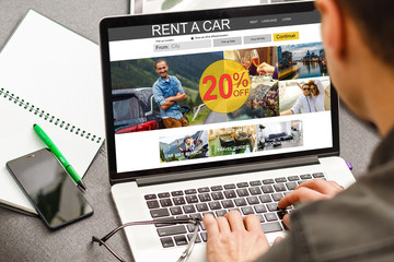 Fototapeta premium Man Planning to Rent a Car on the Internet