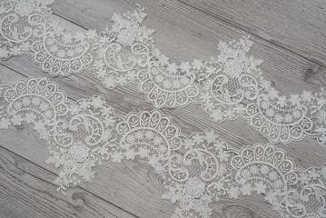 wooden background with spring flowers roses and lace ribbon. Happy womans day. The texture of lace on wooden background.
