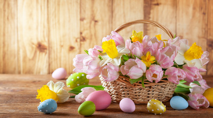 Easter holiday basket with beautiful spring flowers and Easter eggs.