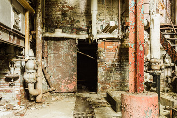 Creepy setting in basement of an abandoned factory with open metal door