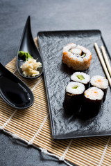 Sushi Set sashimi and sushi rolls served on stone slate 