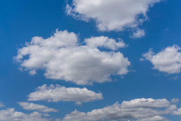 Fototapeta na wymiar White cumulus clouds against a blue sky.