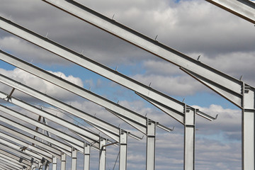 The structure of the building. Steel construction on the sky background. Electroplate steel metal....