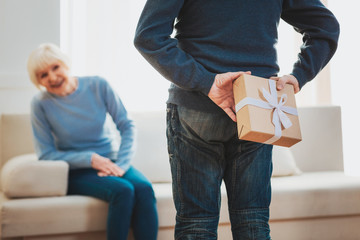 Caring loving husband making surprise for his smiling wife