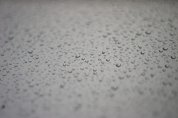 raindrops on window glass on background of cloudy sky