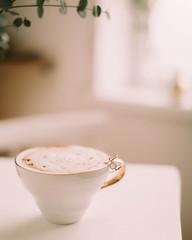 cup of coffee with cream on wooden background