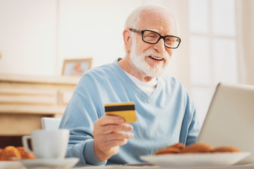 Caring elderly husband feeling amazing while shopping online
