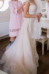 Fototapeta na wymiar bride put on a wedding dress in the room
