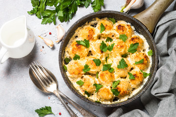 Meatballs in cream sauce with parmesan cheese top view.