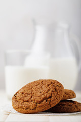 Oatmeal cookies with milk on a wooden table, close-up