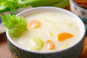 A bowl of cheese soup with celery and poultry meat