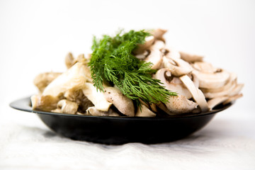 champignons, mushrooms and dill on a black plate