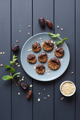 Fototapeta na wymiar Raw vegan gluten free paleo style cookies with melted chocolate and himalayan salt on grey plate