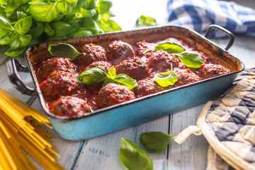 Delisious italian meal meat beef balls with pasta spaghetti and basil in vintage roaster pan
