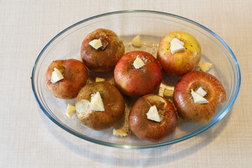 Preparing baked apples with sugar, butter and cinnamon