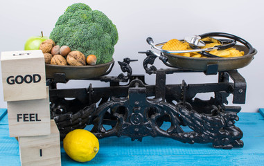 Healthy fruits and vegetables, against potato chips and a stethoscope on scales. Weight loss and proper nutrition