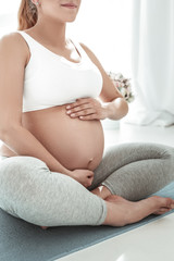 Fototapeta na wymiar Peaceful good-looking pregnant woman in comfortable clothes
