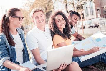 Dark-skinned girl sitting between her friends