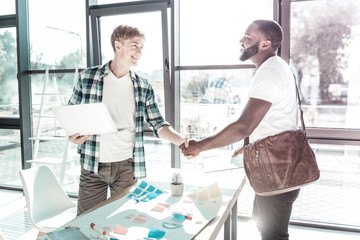 Obraz premium Handsome blonde man shaking hands with his visitor