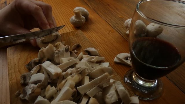 Preparando hongos mientras se toma vino