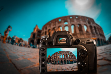 Orange and teal view of a DSLR camera focus on The Colosseum in a crowded touristic day in Rome. UNESCO World Heritage site.