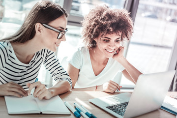Happy international woman sitting in front of computer
