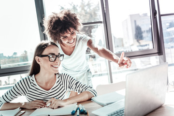 Charming Afro-American female looking at computer