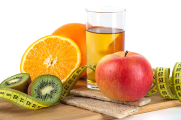 fruits, eggs, orange, apple juice on the wooden board with measurement isolated on white