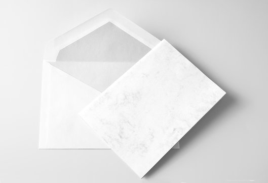Blank folded greeting card and envelope over grey background