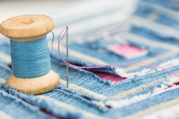 sewing and embroidery concept - installation of spool of blue threads and decorated with a blue...