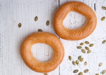 Big bagels and pumpkin seeds on a wooden background