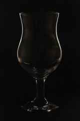 The contrast silhouette of a cocktail glass against dark background