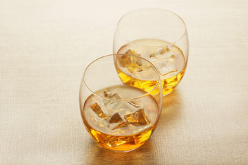 Two glasses with whiskey with ice cubes	