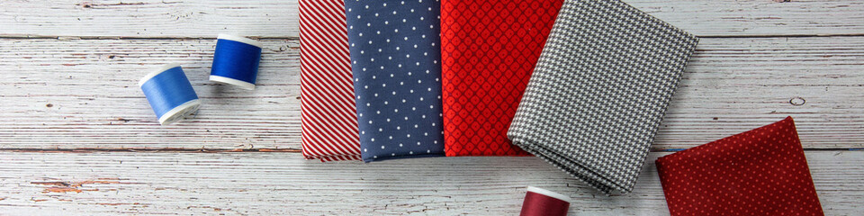 Obraz premium Top view to some pachwork fabrics and threads.