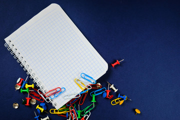 Fototapeta premium school notebook on a blue background, spiral notepad on a dack blue background with selected area and colorful clips