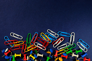 colored paper clips, button  on a dark blue background. 