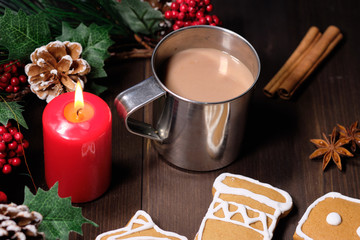 Fototapeta na wymiar ginger biscuit and coffee with milk in the iron cup on brown wood background with Christmas tree 