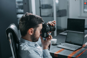 male photographer with a camera  workplace in the office.