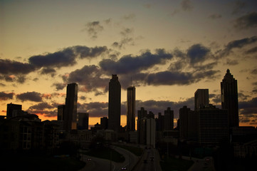 Fototapeta premium A dramatic silhouette of a cluster of buildings set against a golden sunset.