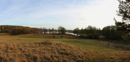 Rural landscape. Panoramic view on lake and forest in autumn.