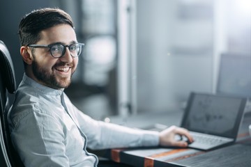 Obraz premium successful business office worker in the workplace with glasses and a beard. concept of career corporation.