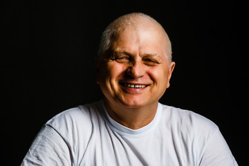 Obraz premium Portrait of an elderly man on black background