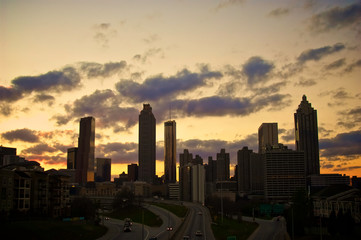 A dramatic silhouette of a cluster of buildings set against a golden sunset.