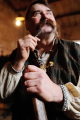 portrait of a Ukrainian Cossack - blacksmith in traditional Ukrainian national clothes on the background of blacksmiths.