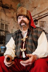 portrait of a Ukrainian Cossack - blacksmith in traditional Ukrainian national clothes on the background of blacksmiths.