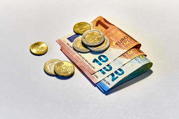 47 euros and 40 eurocents in cash on a white background: banknotes of 20 and 10 euros and coins of...