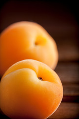 Apricots fresh close up arrangement front view on wooden box selective focus on bright light studio shot