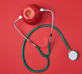 Ripe apple and green medical stethoscope